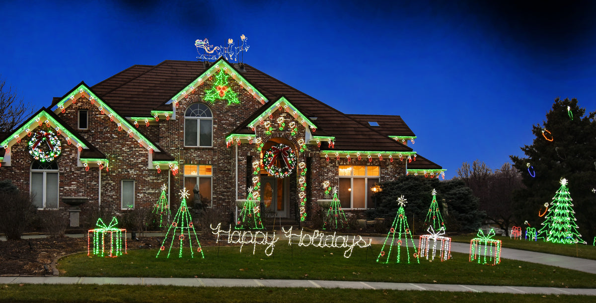 Brick home with mixed Linkables designs on every roofline and peak, lighted trees and gift box displays