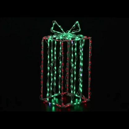 A three-dimensional gift box-shaped LED light decoration with glowing green, red, and white lights on a black background.